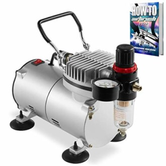 Airbrush compressor with pressure gauge and attached ebook.