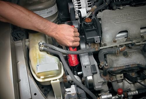 Person performing maintenance on a car engine