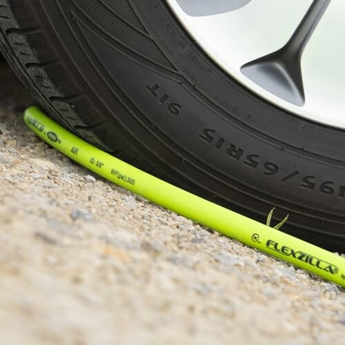 Car tire resting on a Flexzilla air hose.