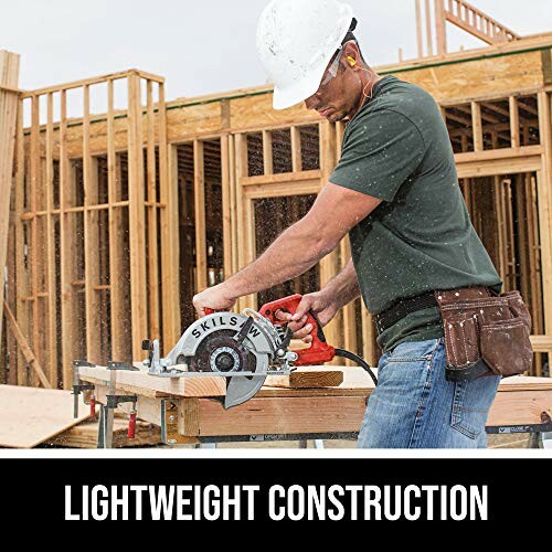 Worker using circular saw at construction site