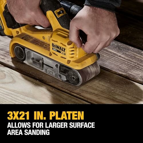 Person using a DEWALT belt sander on wooden surface.