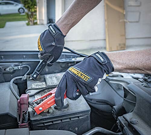 Man jump-starting car battery with cables.