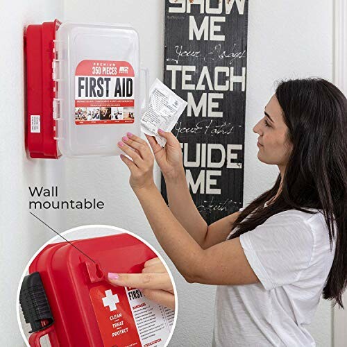 Woman using a wall-mounted first aid kit.